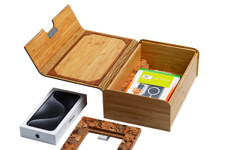 Open wooden box containing a smartphone, camera, and other items on a white background